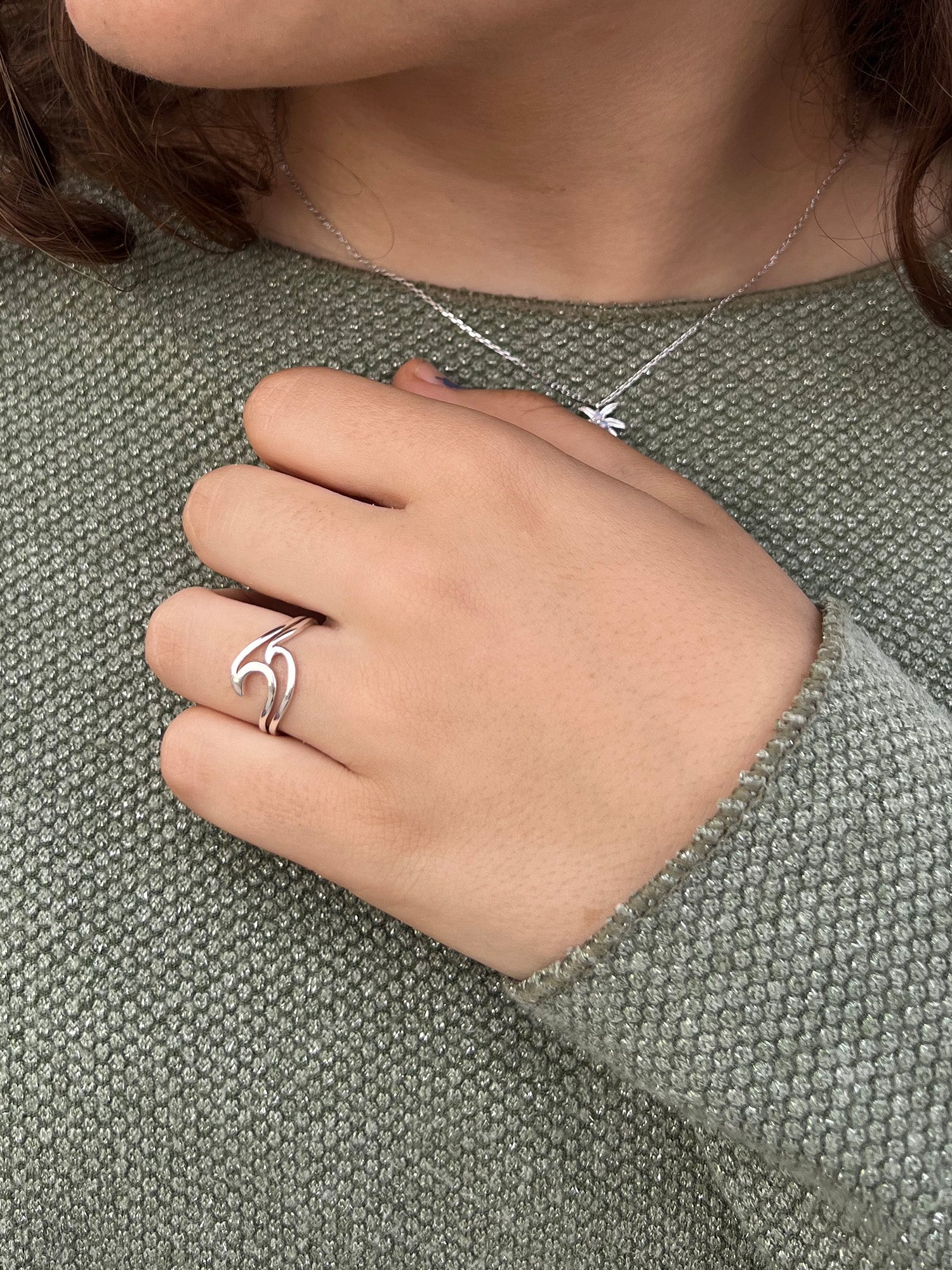 Anillo abierto en plata de ley 925 con diseño curvado y envolvente que recuerda a las olas del mar.