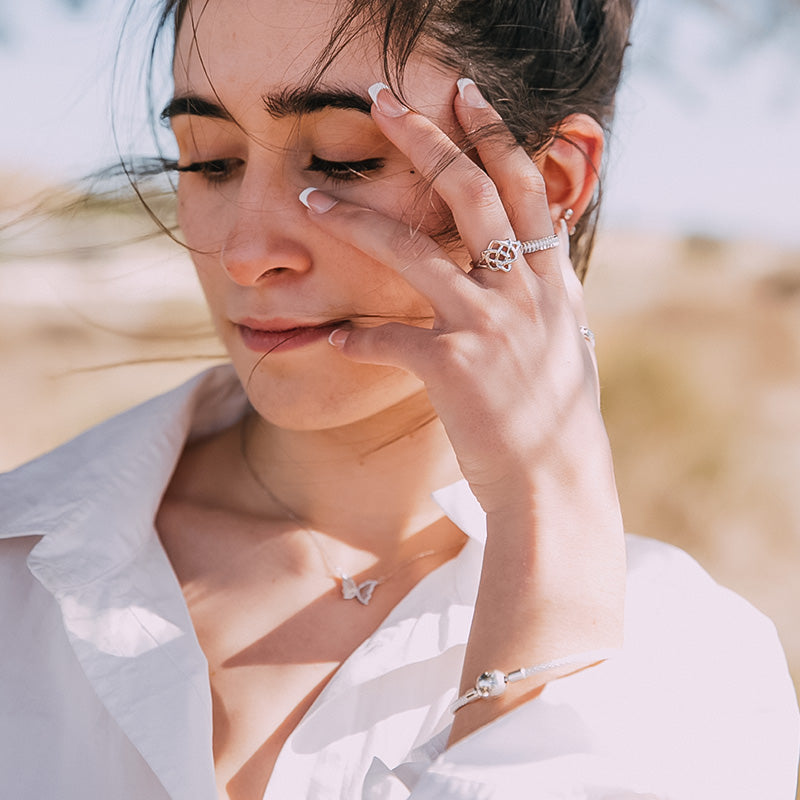 Chica joven con pendientes, collar, anillos y pulsera charms de la colección de joyas Majomajo