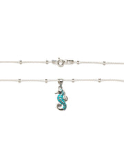 Collar en plata de ley 925 con caballito de mar esmaltado en azul y cadena con bolitas.