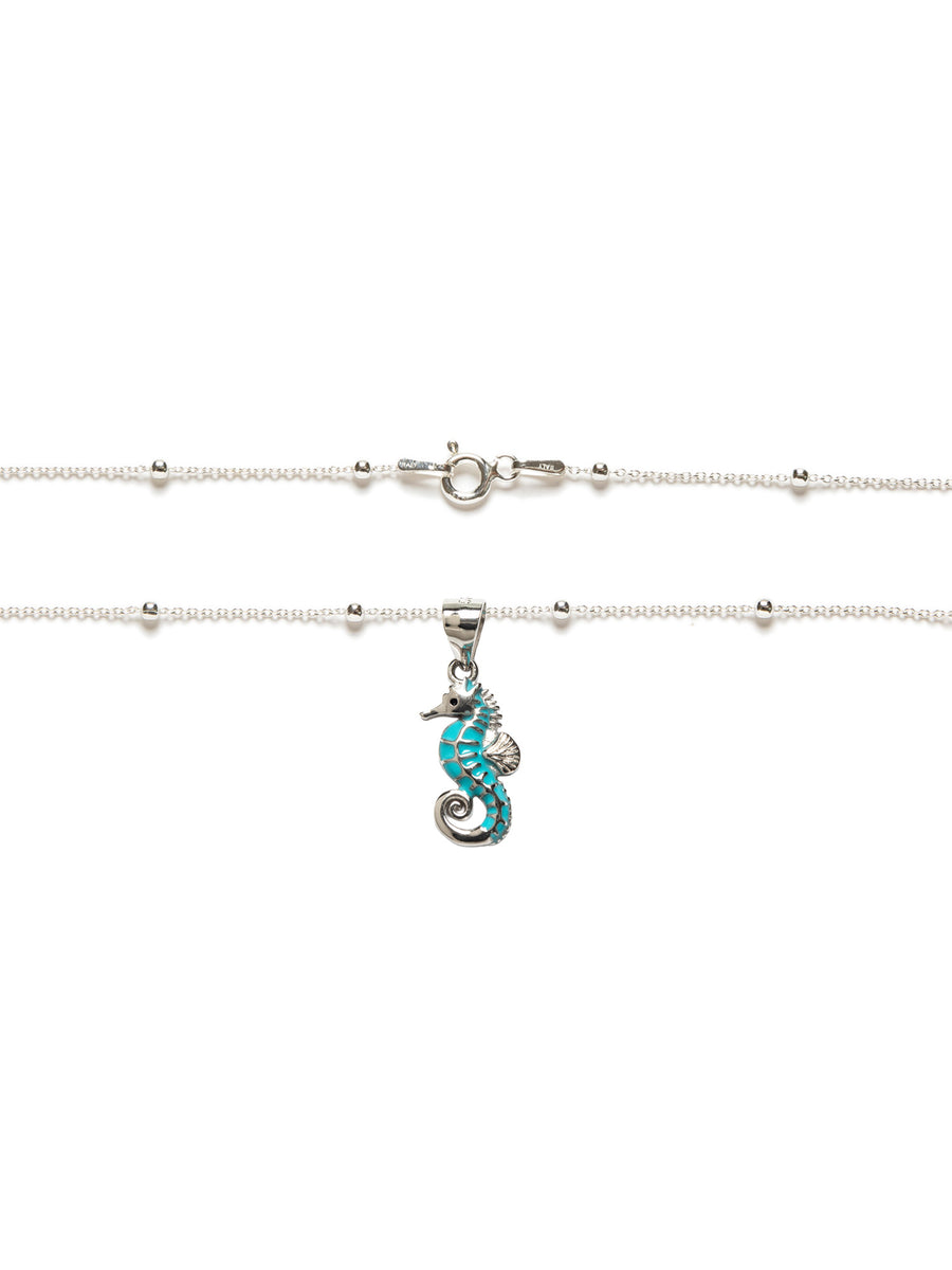 Collar en plata de ley 925 con caballito de mar esmaltado en azul y cadena con bolitas.
