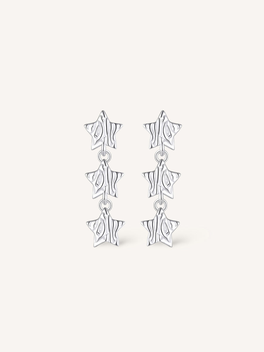 Pendientes largos compuestos por tres estrellas de plata de ley.
