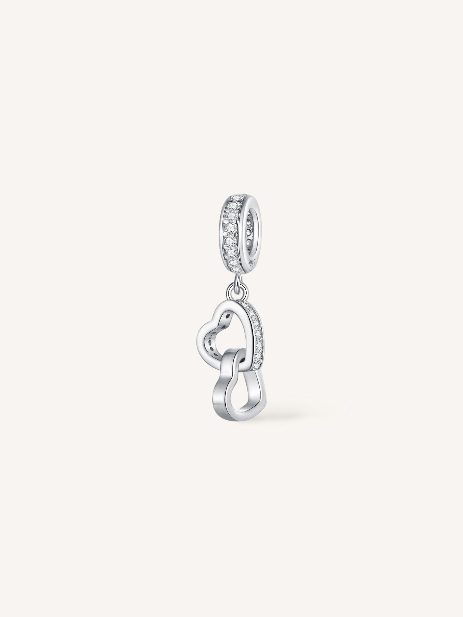 Charm de plata de ley formado por dos corazones entrelazados con circonitas.